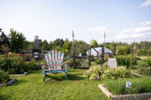 Large lawn chair surrounded by community garden beds at JD Rivers.