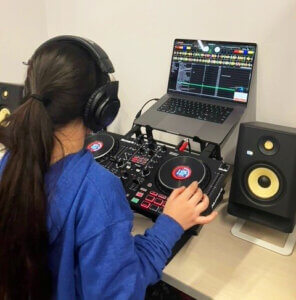 Young girl using DJ equipment at Spark'd Studios. 