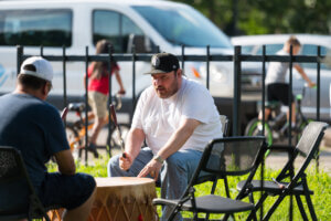 Two men playing a drum at the kickoff party.