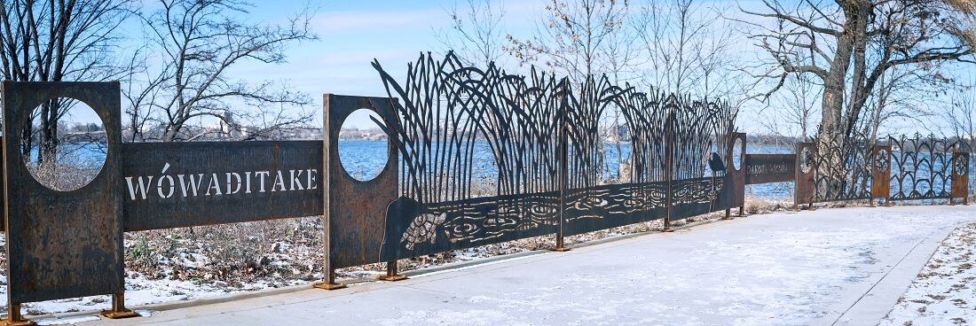 The decorative metal railing depicting Indigenous plants and animals and the Dakota word "Wowaditake," which translates to "Courage" in English