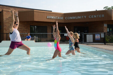 Youth participate in an aqua yoga class in the wading pool at Armatage Park.