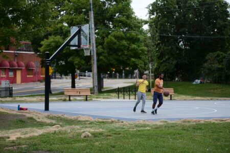 Two men play basketball on the new Currie Park basketball court.