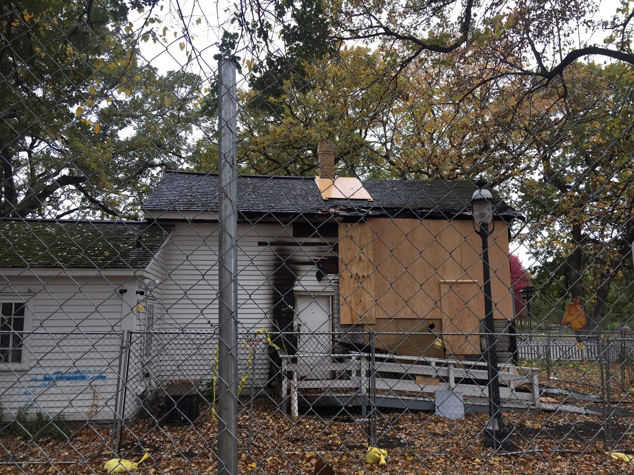 The Stevens House after a suspected arson, boarded up behind two chain link fences