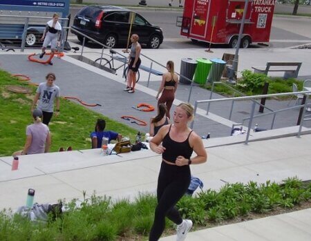 Runner jogging past daytime activities in Downtown Parks